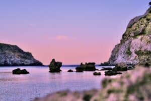 black rock formation on body of water during daytime